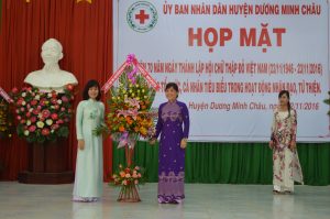 Bà Trần Thị Kim Duyên, Chủ tịch danh dự Huyện Hội (áo tím) nhận hoa chúc mừng của Huyện ủy